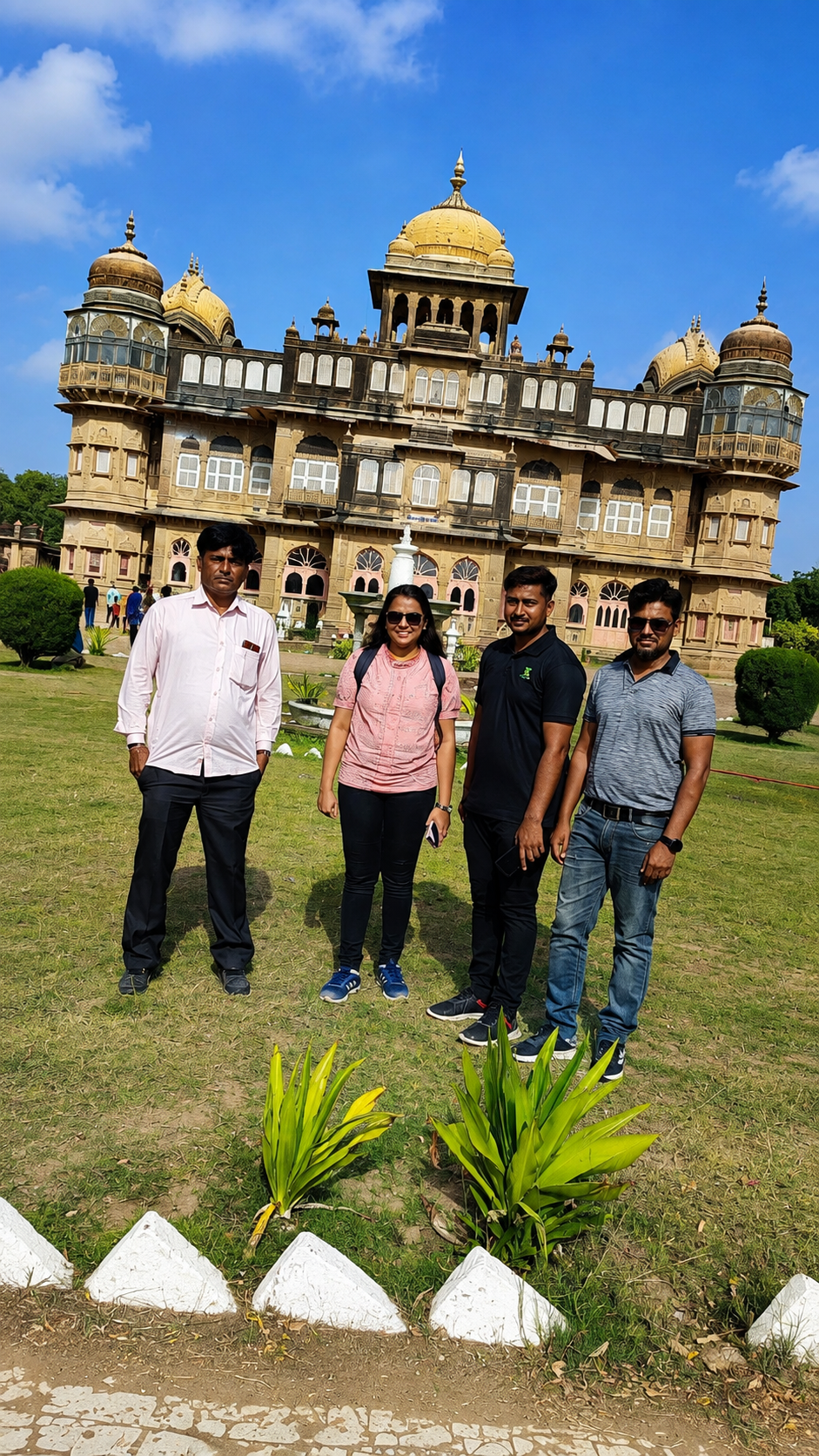 Group of four tourists in front of Vijay Vilas Palace, Mandvi, Kutch